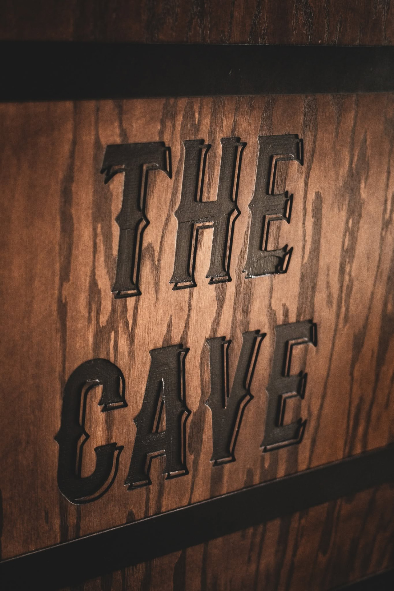 Hand-carved The Cave sign on the shop wall
