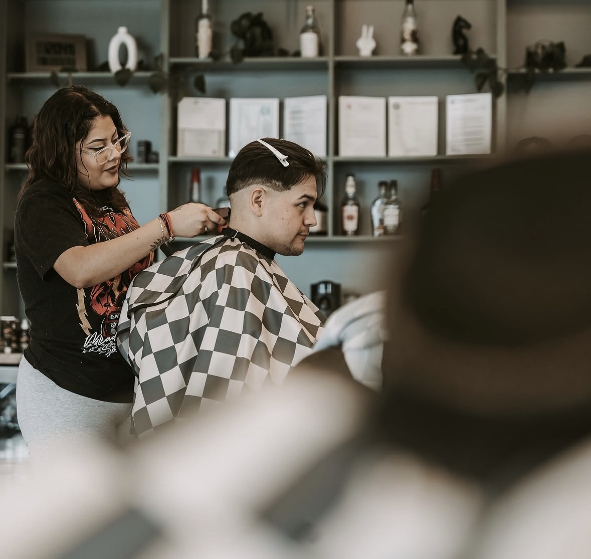 Barber cleaning up a neckline on a taper cut in the shop at The Cave, Springdale AR