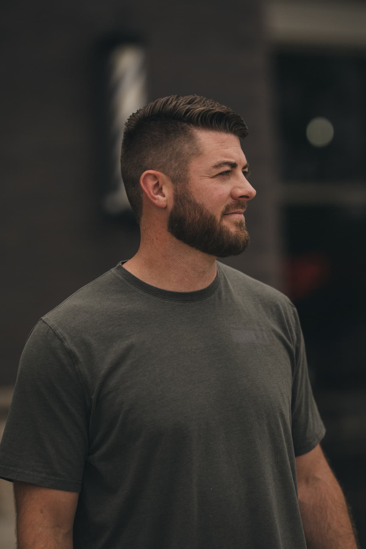 High skin fade with a side-swept top and shaped beard at The Cave, Springdale AR